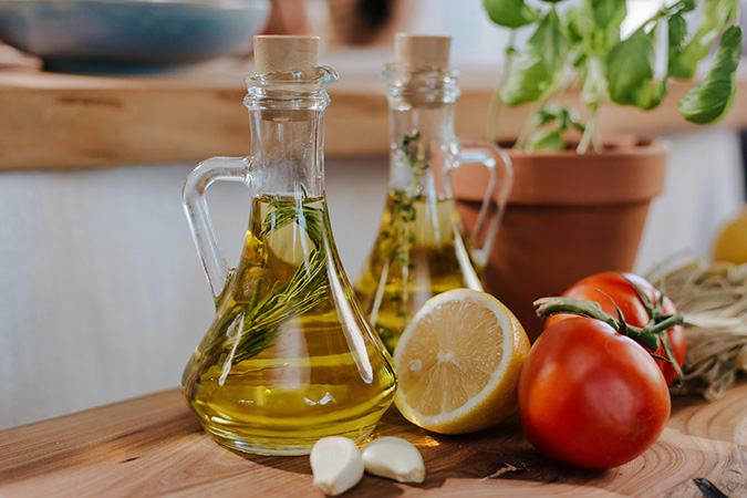 Vinagre de maçã emagrece? Garrafa de vinagre de maçã com maçãs